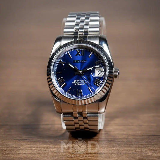Silver watch with a blue face on a wooden surface