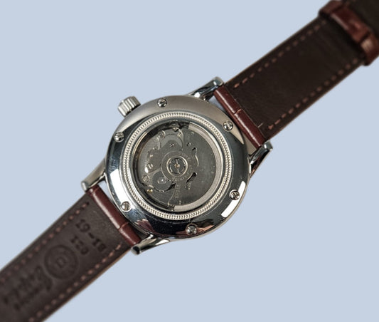 Watch with a brown leather strap on a light blue background