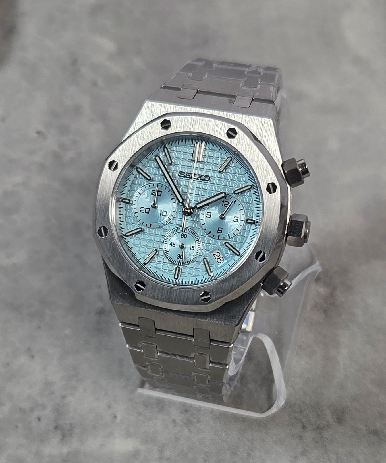 Silver Seiko watch on a gray background