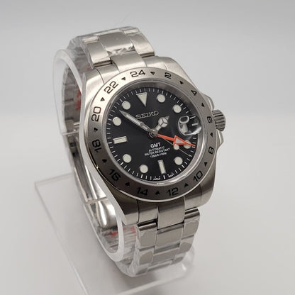 Silver watch with a black dial on a white background