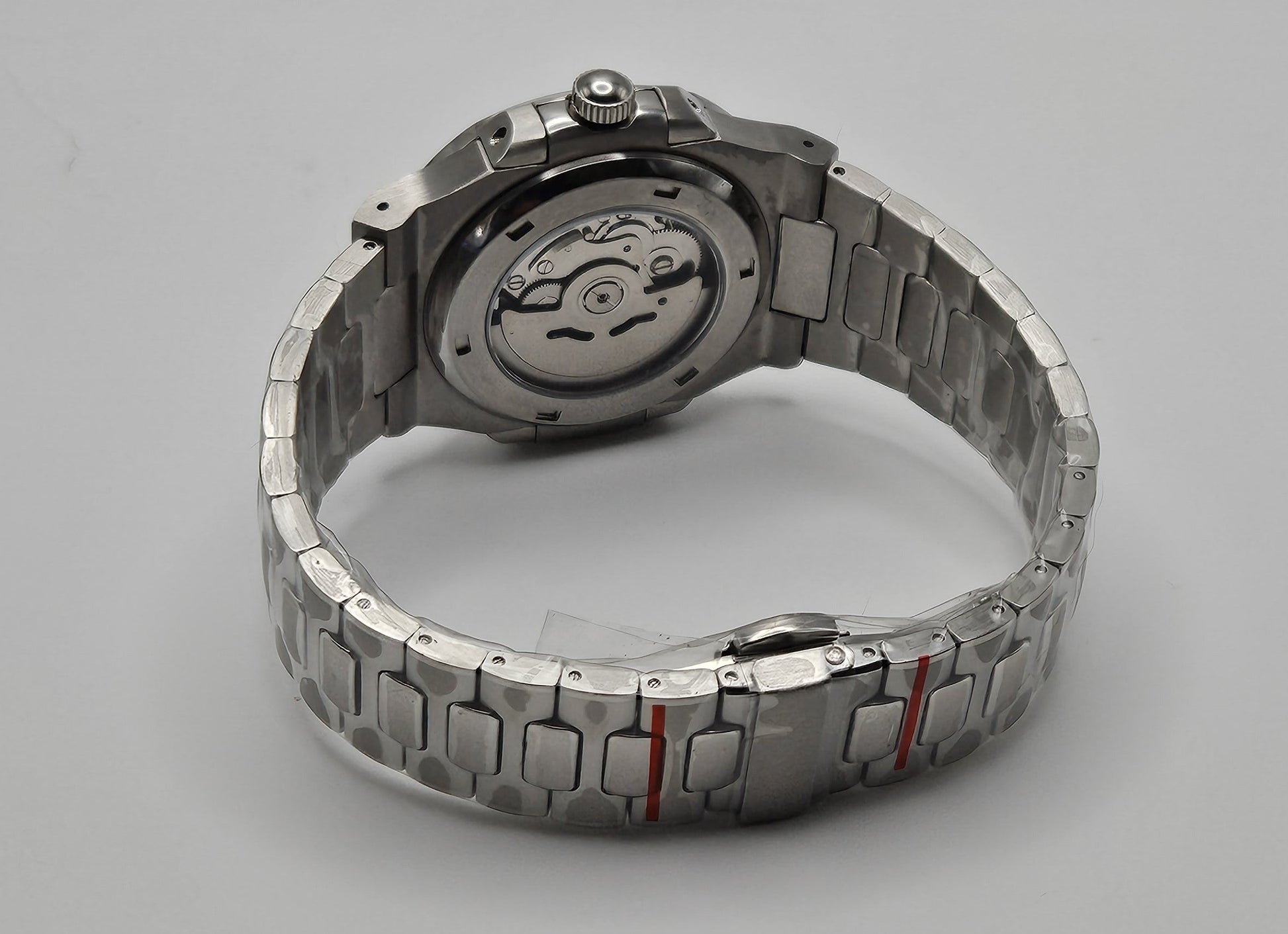 Silver watch with a detailed mechanism on a gray background