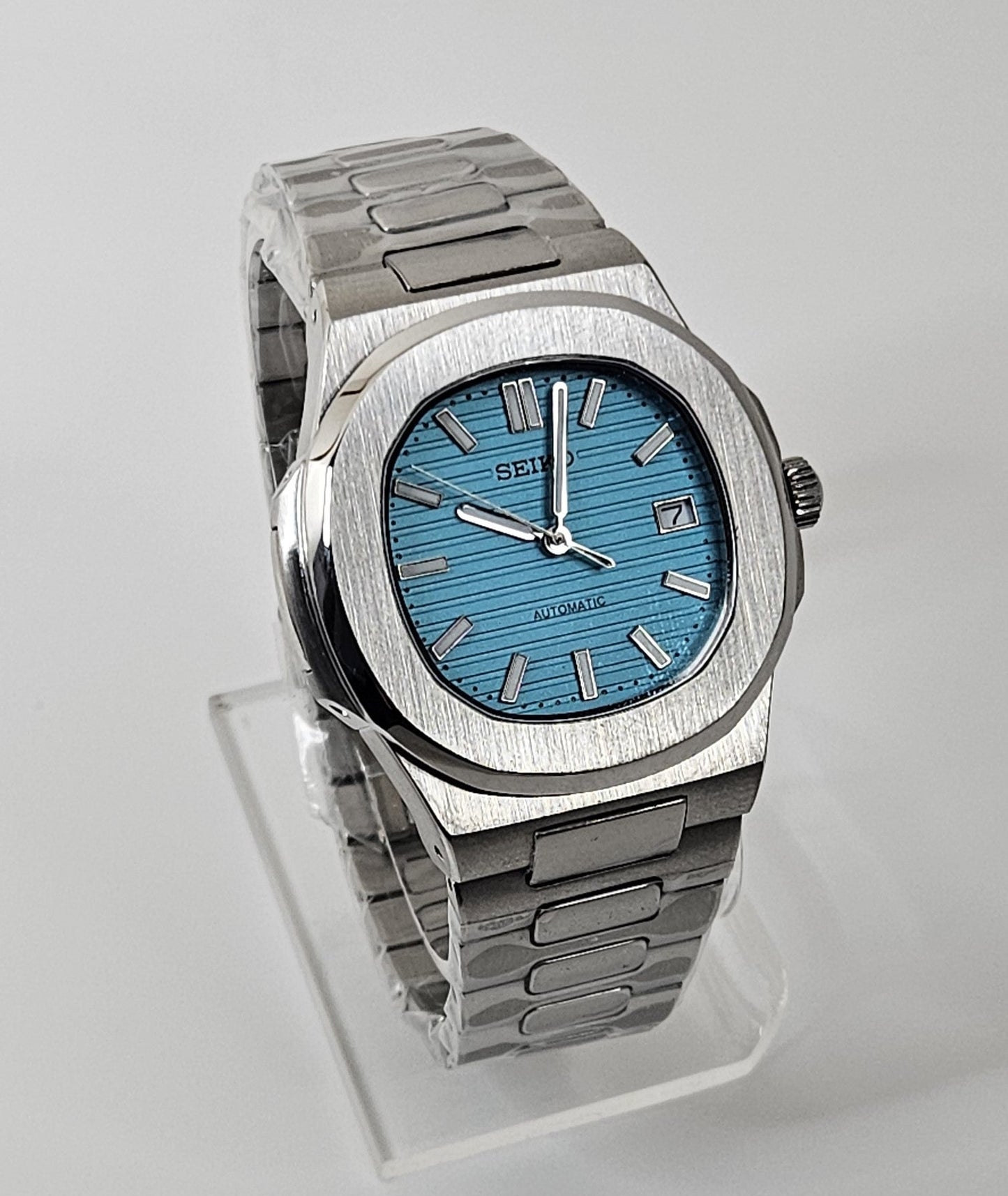 Silver watch with a blue face on a light gray background