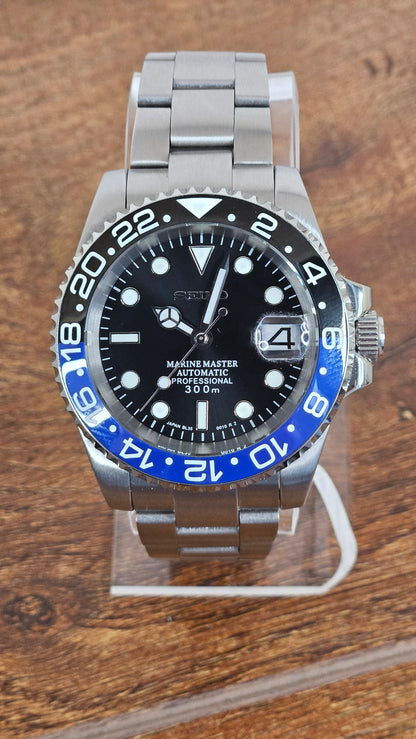 Watch with black face and blue bezel on a wooden surface