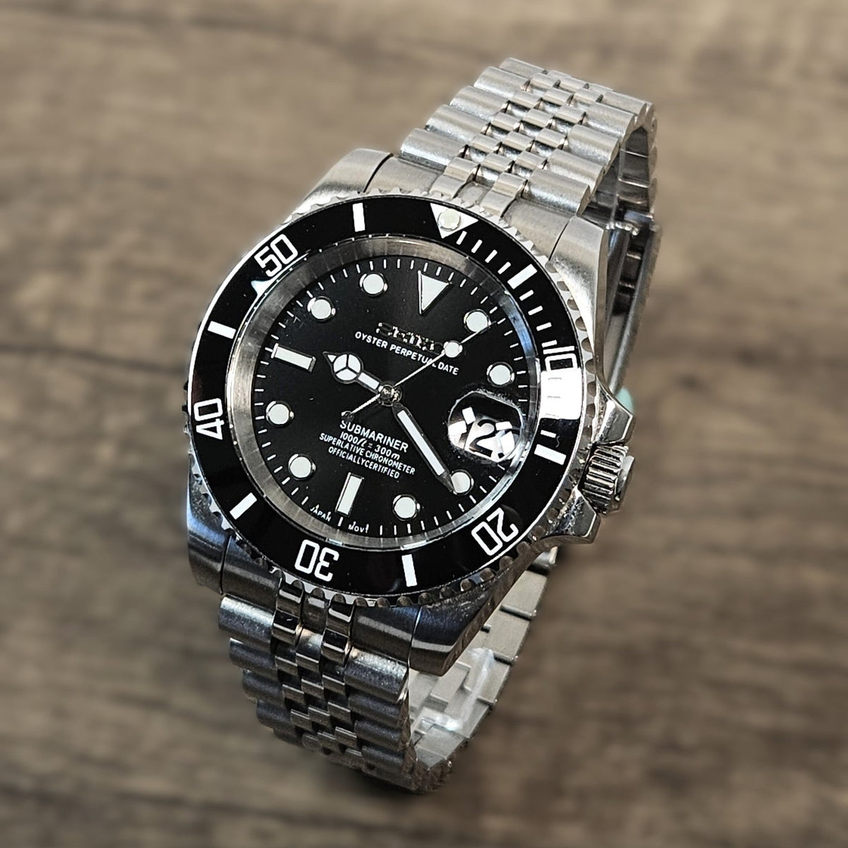 Silver wristwatch with black dial on a wooden surface