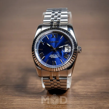 Silver watch with a blue face on a wooden surface