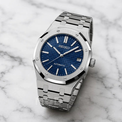 Silver Seiko watch with blue face on a marble background