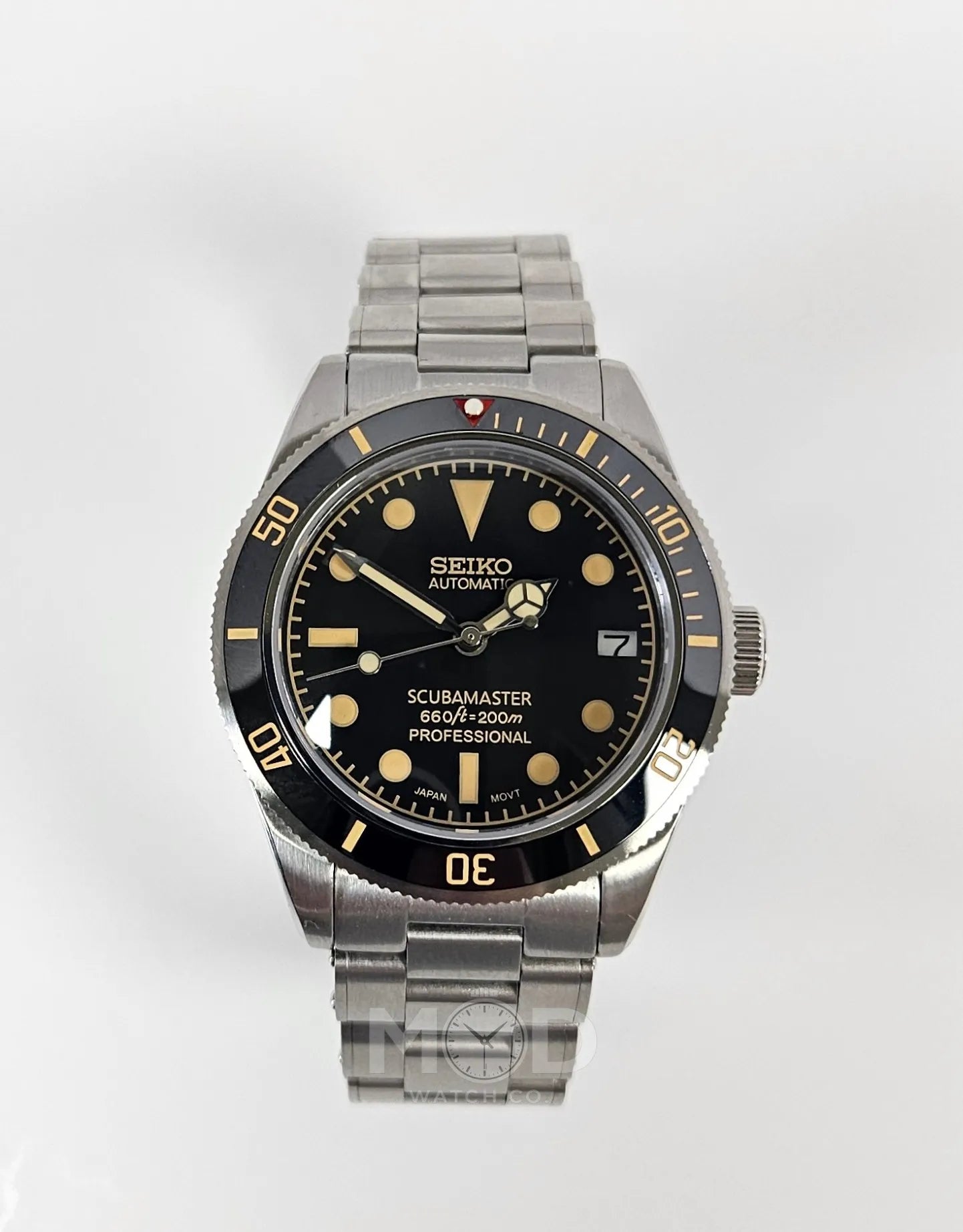 Seiko watch with black dial and silver metal strap on a white background