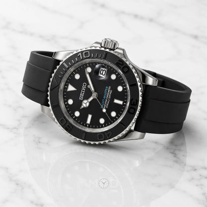 Black Seiko watch with a rubber strap on a marble surface