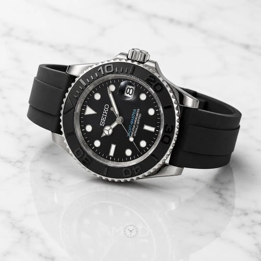 Black Seiko watch with a rubber strap on a marble surface