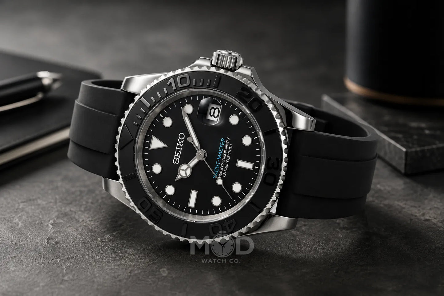 Seiko watch with black rubber strap on a dark surface