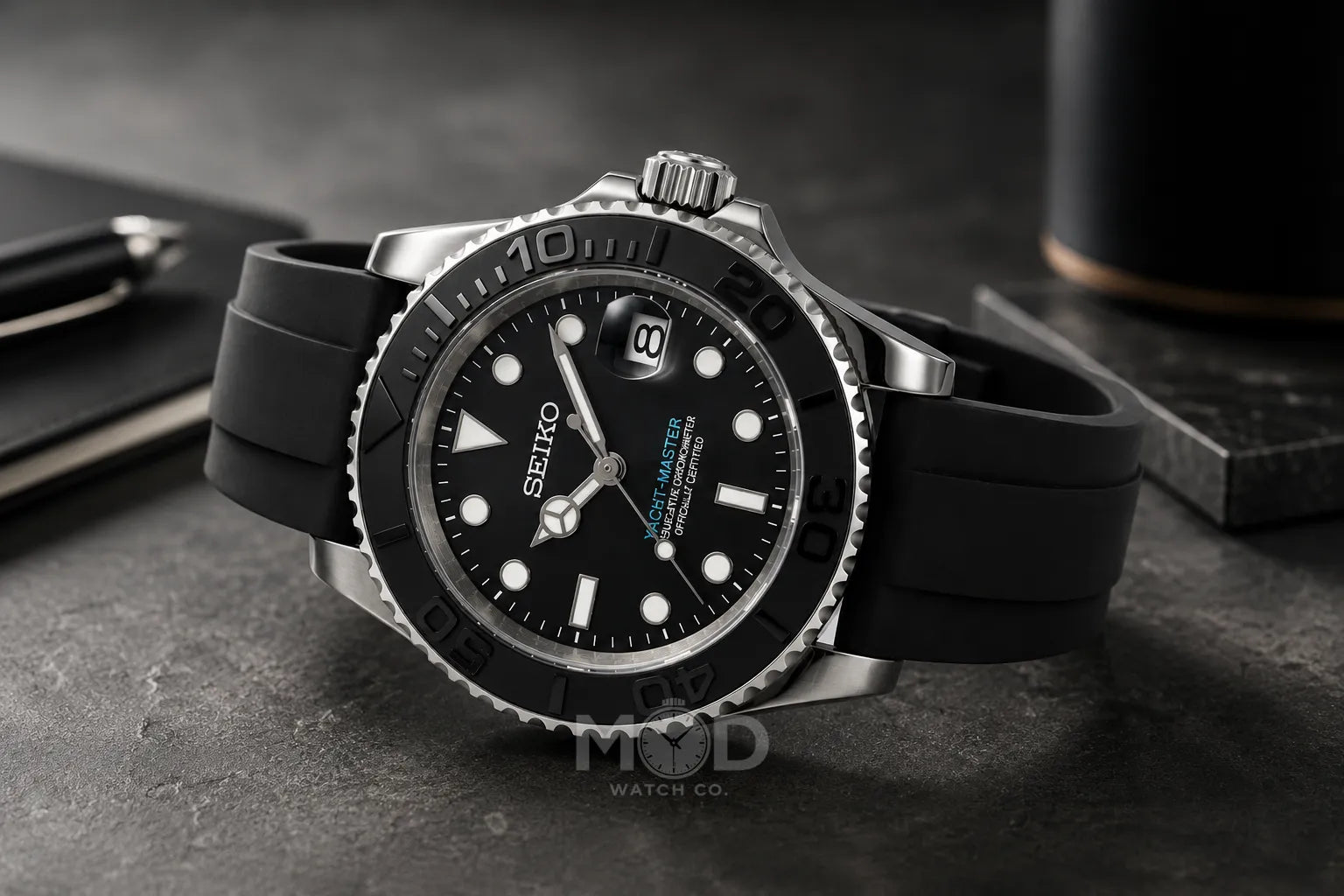 Seiko watch with black rubber strap on a dark surface