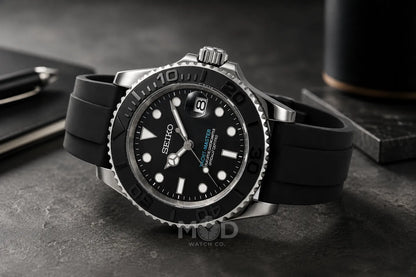 Seiko watch with black rubber strap on a dark surface