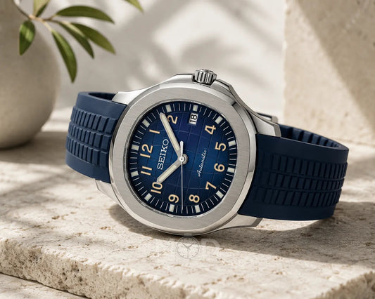 Blue Seiko watch on a stone surface with a plant in the background