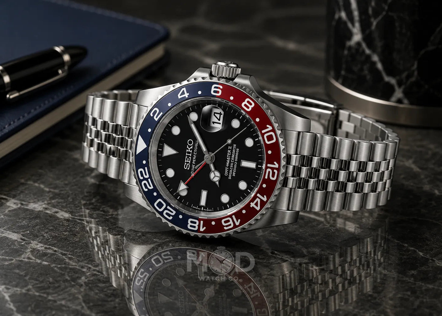 Seiko watch with a silver bracelet on a reflective surface