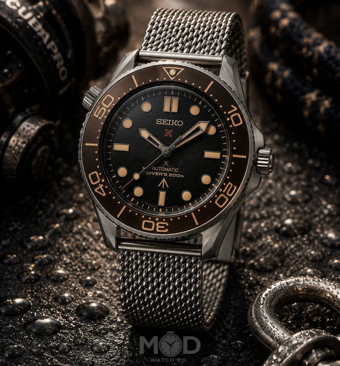 Seiko watch with black dial and mesh band on a dark textured background
