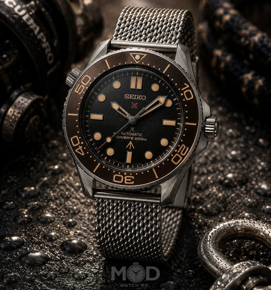 Seiko watch with black dial and mesh band on a dark textured background