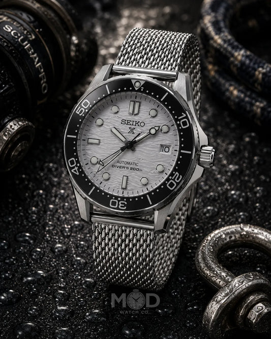 Seiko watch with a silver mesh strap on a dark textured background