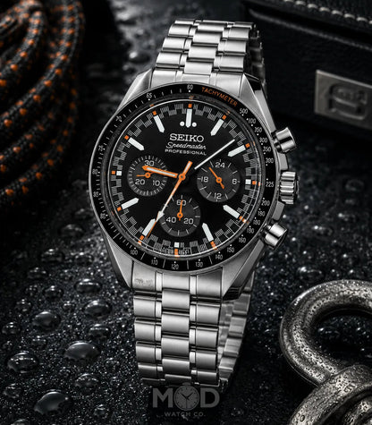 Seiko watch with black dial and silver metal strap on a dark textured background