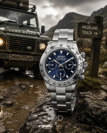 Silver Seiko watch on a rock with a Land Rover and sign in the background