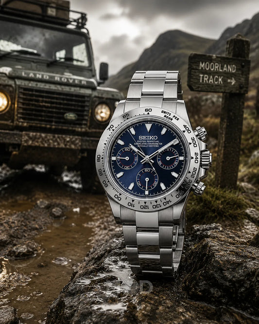 Silver Seiko watch on a rock with a Land Rover and sign in the background