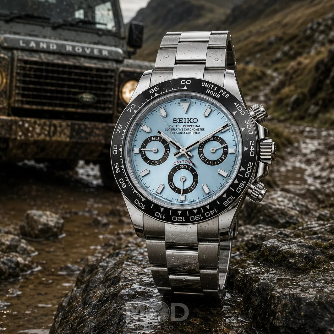 Silver Seiko watch on a rock with a Land Rover in the background