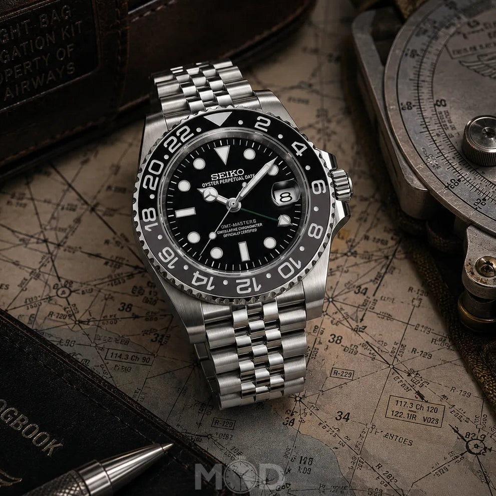 Silver Seiko watch on a map with navigation tools