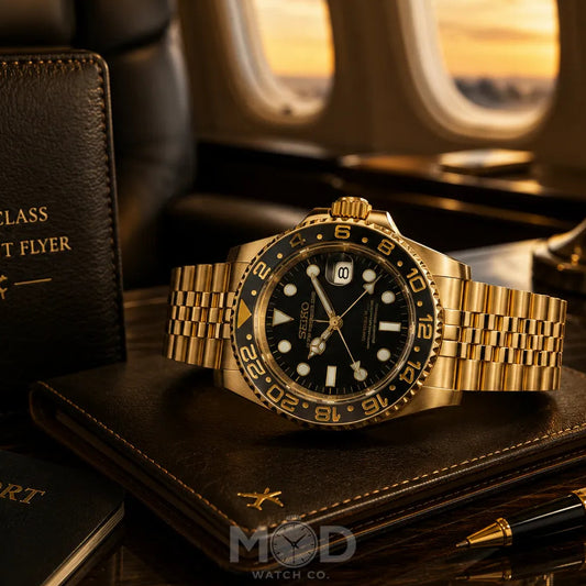 Gold watch on a first class frequent flyer book with passport and pen, airplane window in background