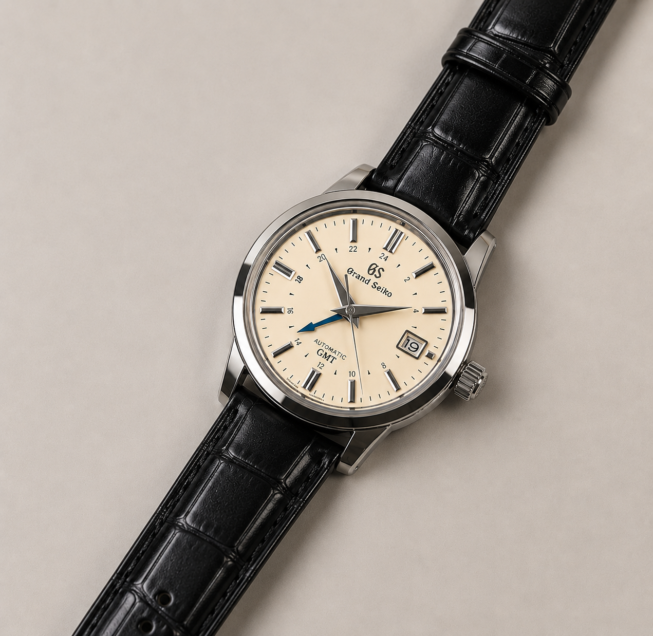 Wristwatch with black leather strap and cream dial on a beige background