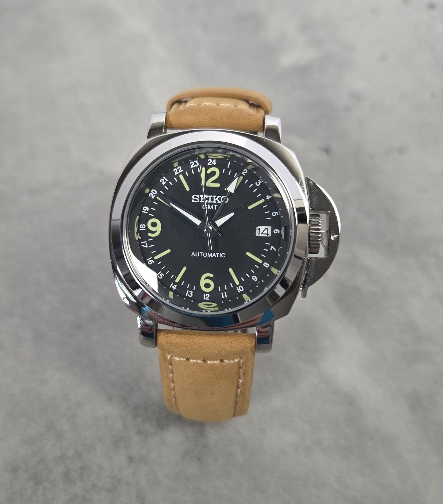 Seiko Panerai watch with brown leather strap on a gray background