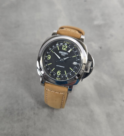 Seiko watch with brown leather strap on a gray concrete background