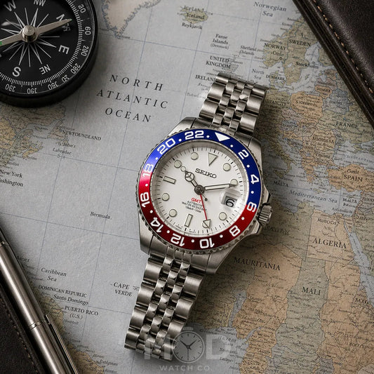 Silver Seiko watch with red and blue accents on a world map