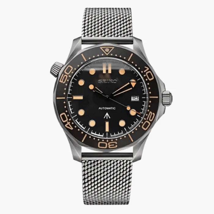 A Seiko automatic watch with a black dial, black rotating bezel, and a silver stainless steel mesh strap, shown against a light gray background.