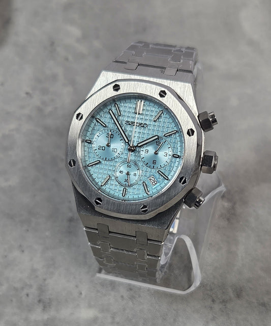 Silver Seiko watch on a gray background