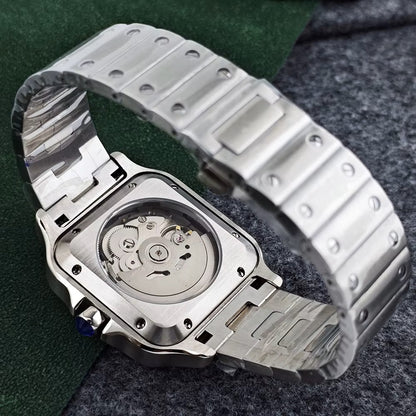 Silver watch with open face showing mechanical components on a textured surface