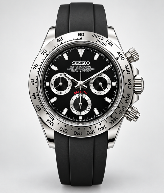 A Seiko Daytona wristwatch with a black dial, silver-tone stainless steel case, and a black rubber strap, shown against a light gray background.